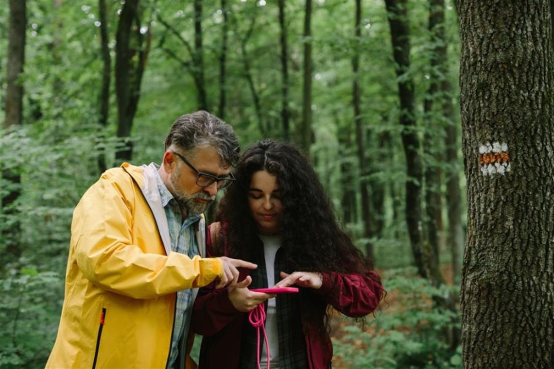 Father and daughter looking at a nature app on their phone