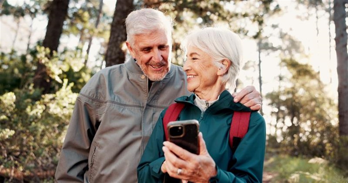 Senior couple hiking using their phone