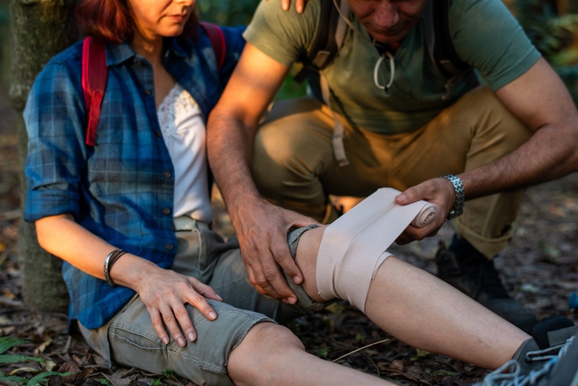 man administering wilderness first aid on woman