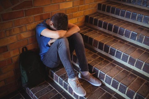 sad boy sitting on steps