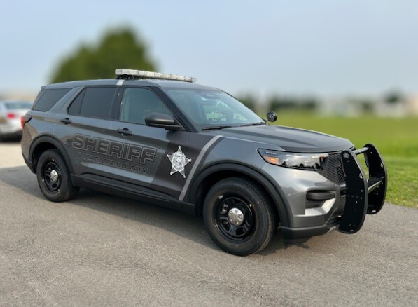 Outagamie County Sheriff's Office squad vehicle parked with green trees and grass in the background.