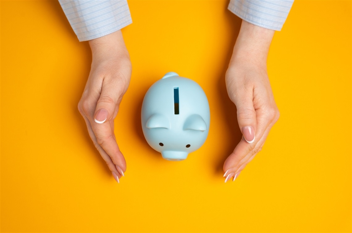 Hands surrounding a piggy bank