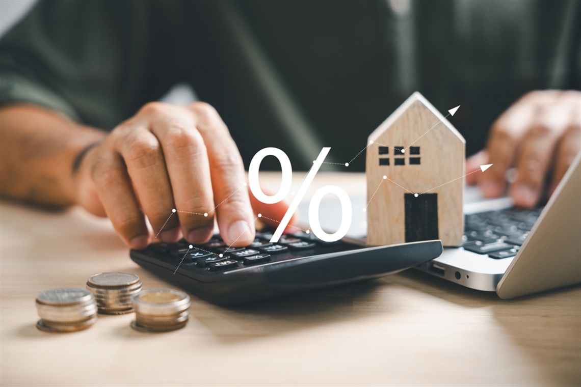 calculator with money and house around it