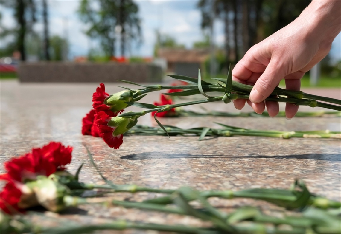 Man laying flowers on memorial 