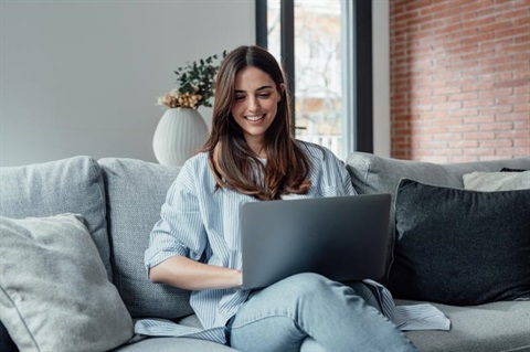 Woman Sitting on Couch with Laptop