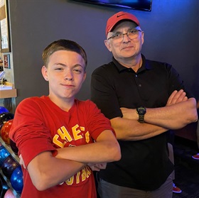 boy with arms crossed, adult male with arms crossed